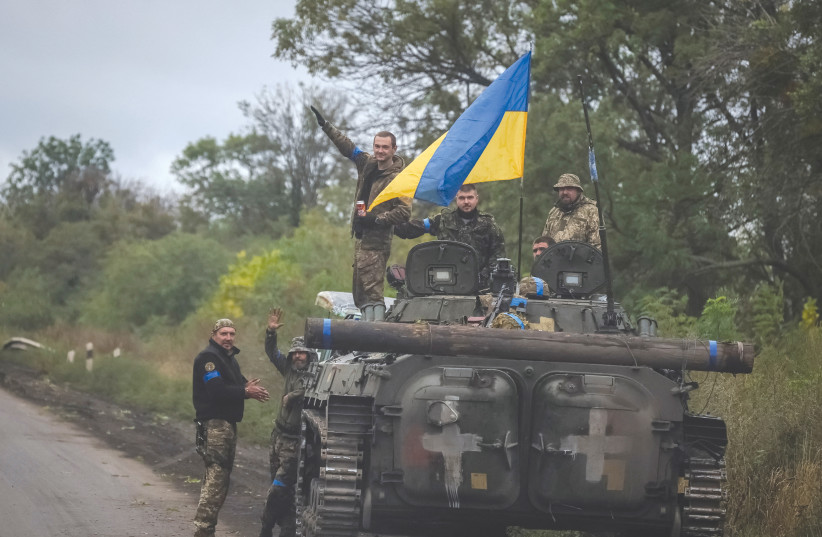  UKRAINIAN SERVICE members stand on an infantry fighting vehicle, near the town of Izium, recently liberated by Ukrainian Armed Forces, on Tuesday. (photo credit: GLEB GARANICH/REUTERS)