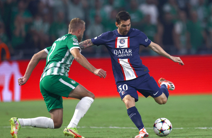 Paris Saint-Germain's Lionel Messi shoots against Maccabi Haifa’s Daniel Sundgren during the teams’ Champions League clash at Sammy Ofer Stadium this week. (credit: RONEN ZVULUN/REUTERS)