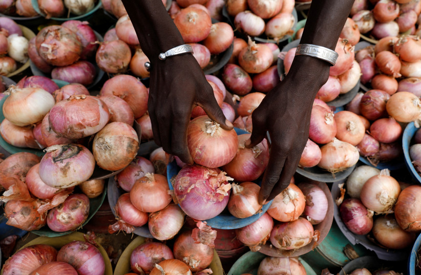  A vendor arranges onions for sale at Mile 12 International Market in Lagos, Nigeria May 13, 2022. Picture taken May 13, 2022. (photo credit: REUTERS/Temilade Adelaja TPX IMAGES OF THE DAY)