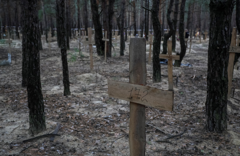 Crosses with numbers are seen at a place of mass burial, as Russia's attack on Ukraine continues, in the town of Izium, recently liberated by Ukrainian Armed Forces, in Kharkiv region, Ukraine, September 16, 2022. (credit: REUTERS/GLEB GARANICH)