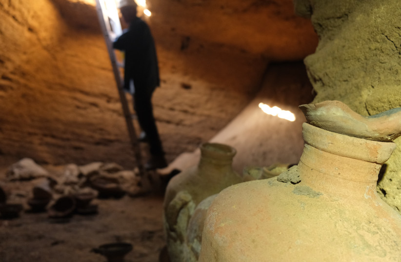  A member of the Israel Antiquities Authority team inspects the 3,300-year-old burial cave found under the Palmachim Beach.  (credit: EMIL ALADJEM/IAA)
