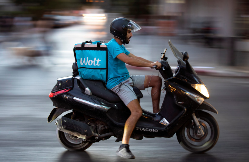  A courier working with Wolt, a meal delivery app service, rides a scooter as he delivers an order from a restaurant, amid the coronavirus disease (COVID-19) crisis, in Tel Aviv, Israel July 9, 2020. (photo credit: REUTERS/AMIR COHEN)