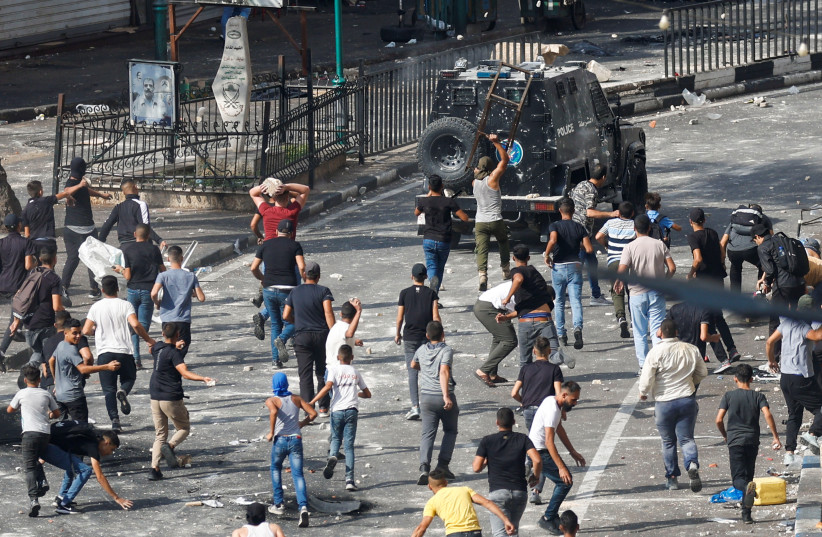  Palestinian demonstrators protesting the arrest of two Palestinian militants clash with Palestinian and Israeli security forces, in Nablus on September 20, 2022.  (photo credit: REUTERS/MOHAMAD TOROKMAN)