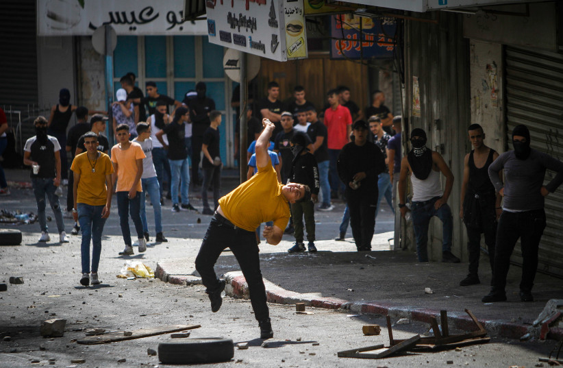  Palestinians clash with Palestinian security forces in Nablus, in the West Bank on September 20, 2022, following the arrest of Hamas members by Palestinian security forces, September 20, 2022. (photo credit:  Nasser Ishtayeh/Flash90)