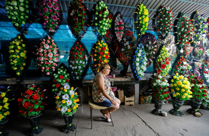  A vendor sells artificial flowers and funeral wreaths at a street market during Ukraine-Russia conflict in the Russia-controlled city of Kherson, Ukraine July 26, 2022.  (credit: REUTERS/ALEXANDER ERMOCHENKO)