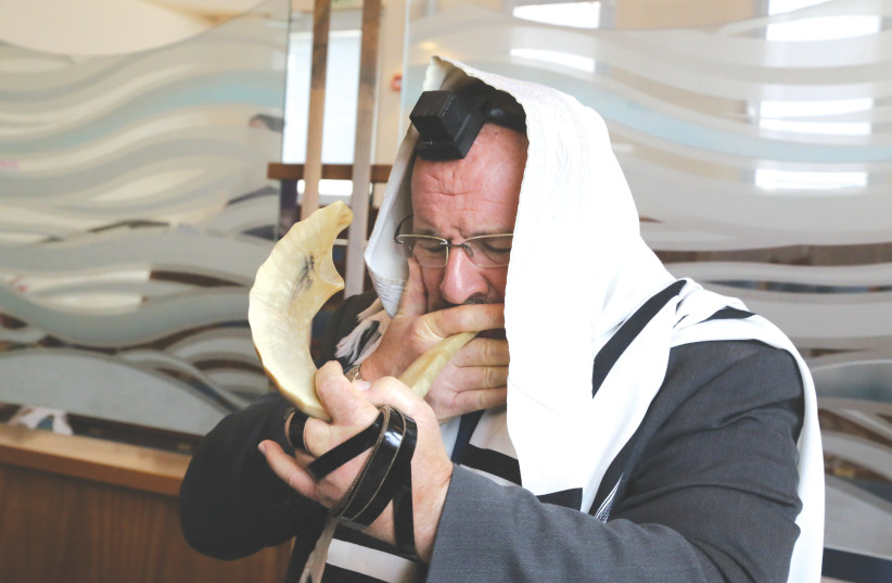  A MAN blows a shofar at a synagogue during the month of Elul, ahead of Rosh Hashanah.  (photo credit: GERSHON ELINSON/FLASH90)