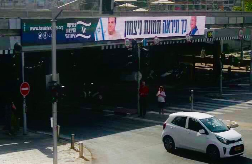 A billboard depicting MKs Ahmad Tibi and Ayman Odeh with Israeli flags with the caption “This is how a picture of victory will look.” (credit: ISRAEL VICTORY PROJECT)