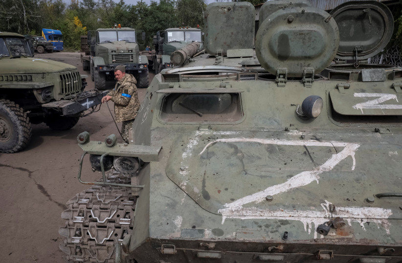  Ukrainian serviceman prepares to tow a destroyed Armoured Personnel Carrier (APC), as Russia's attack on Ukraine continues, in the town of Izium, recently liberated by Ukrainian Armed Forces, in Kharkiv region, Ukraine September 20, 2022 (credit: GLEB GARANICH/REUTERS)