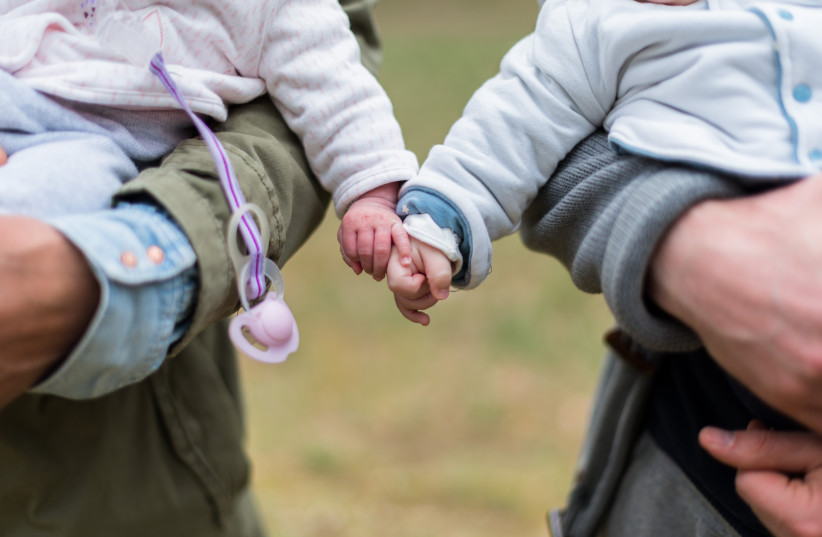  Illustrative photo of two babies holding hands (photo credit: PXHERE)