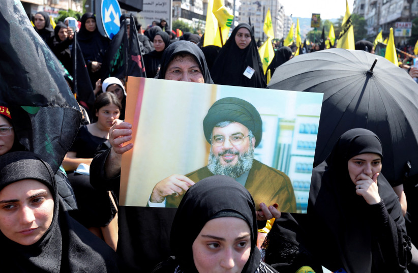  A Shi'ite Muslim woman carries a picture of Lebanon's Hezbollah leader Sayyed Hassan Nasrallah during a religious procession to mark Ashura in Beirut's suburbs, Lebanon August 9, 2022. (photo credit: REUTERS/AZIZ TAHER)
