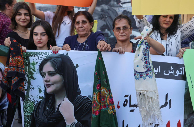  Women hold a picture of Mahsa Amini during a sit-in following her death, at Martyrs' Square in Beirut, Lebanon September 21, 2022 (photo credit: REUTERS/MOHAMED AZAKIR)