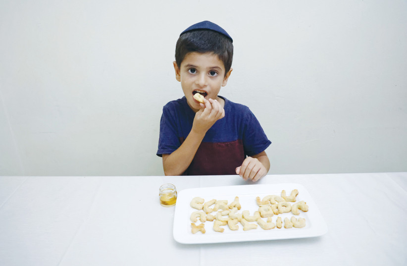  ROSH HASHANAH joy: Dipping the apple in the honey (Illustrative). (photo credit: GERSHON ELINSON/FLASH90)