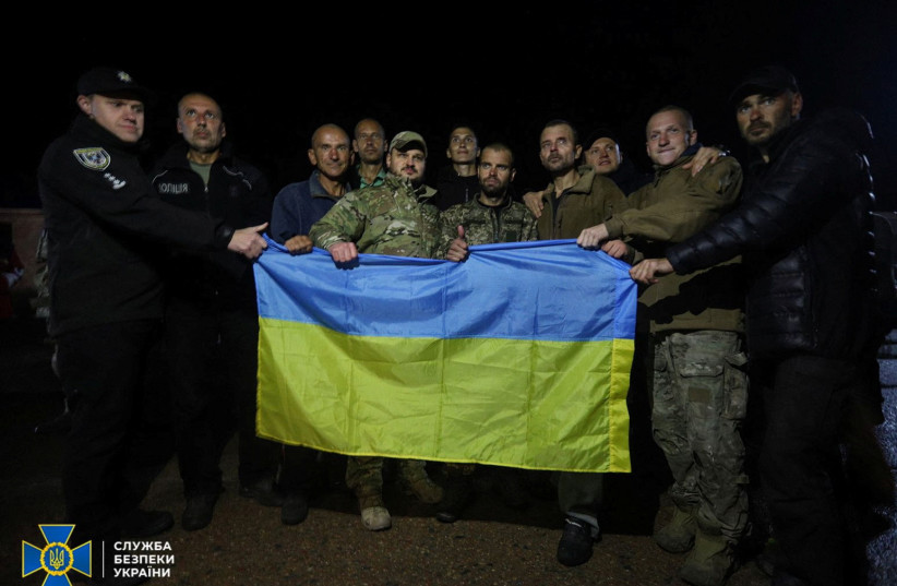  Ukrainian prisoners of war (POWs) pose for a picture with a national flag after a swapping in Chernihiv region (credit: Press service of the State Emergency Service of Ukraine/Handout via REUTERS)