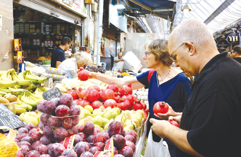  SHOPPING FOR pomegranates in the Mahaneh Yehudah shuk. That even A stitch of solidarity remains in this country after five election campaigns in three-and-a-half years, campaigns that highlight and underline the country’s division, is a testament to this country’s overall internal strength. (photo credit: MARC ISRAEL SELLEM/THE JERUSALEM POST)