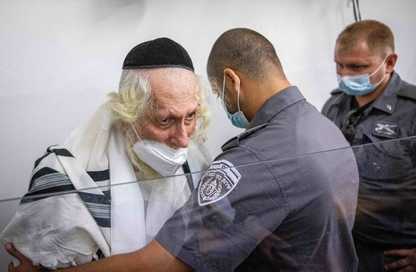  Rabbi Eliezer Berland covered with a prayer shawl arrives for a court hearing arrives for a police investigation at a police station in Jerusalem, November 2, 2021.  (credit: YONATAN SINDEL/FLASH90)