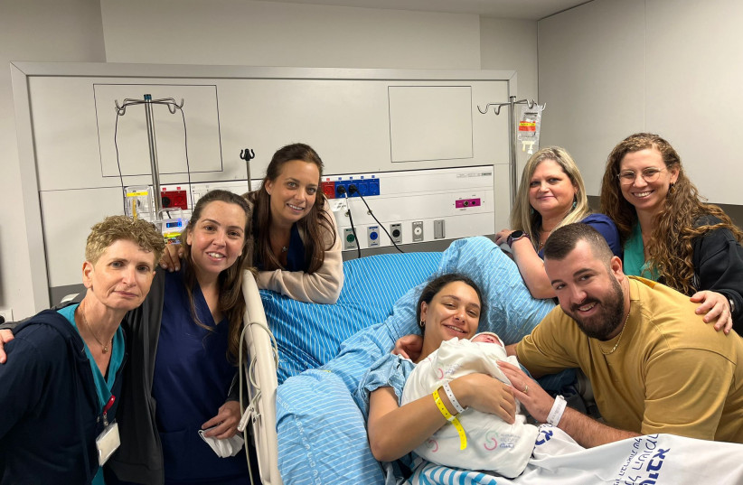 Natalie Peles, her husband Yarin and their daughter together and the team that accompanied the birth. (photo credit: SHEBA MEDICAL CENTER)