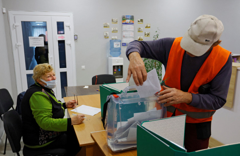 A municipal worker casts his ballot during a referendum on the secession of Zaporizhzhia region from Ukraine and its joining Russia, in the Russian-controlled city of Melitopol in the Zaporizhzhia region, Ukraine, September 26, 2022. (credit: REUTERS/ALEXANDER ERMOCHENKO)