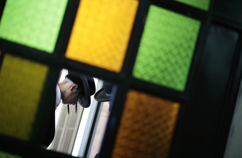  Members of a Jewish community are seen through a stained-glass door in the village of San Juan La Laguna August 24, 2014 (credit: JORGE DAN LOPEZ/REUTERS)