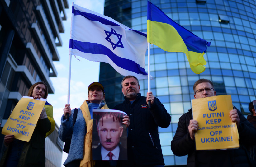  Demonstrators carry placards and flags during a protest march against the Russian invasion to the Ukraine, in Tel Aviv, on February 26, 2022.  (photo credit: TOMER NEUBERG/FLASH90)