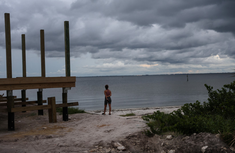  Nyasia Arzuaga looks out at storm clouds, as Hurricane Ian spun toward the state carrying high winds, torrential rains and a powerful storm surge, at Ben T. Davis Beach in Tampa, Florida, US, September 27, 2022.  (photo credit: SHANNON STAPLETON/ REUTERS)