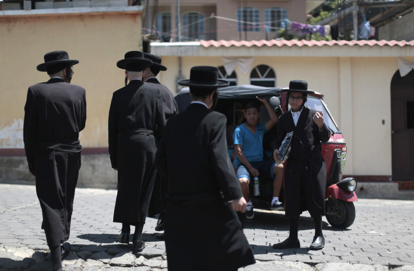  Members of a Jewish community walk near a motor taxi in the village of San Juan La Laguna August 24, 2014. (photo credit: JORGE DAN LOPEZ/REUTERS)