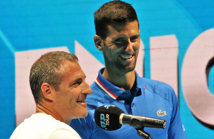  Yoni Erlich (left) and Novak Djokovic speak together on the court at the Tel Aviv Expo yesterday. The 45-year-old Israeli and the Serbian former world No. 1 were supposed to pair up for the doubles competition at the Tel Aviv Watergen Open, but Erlich was forced to pull out (photo credit: ORI LEWIS)