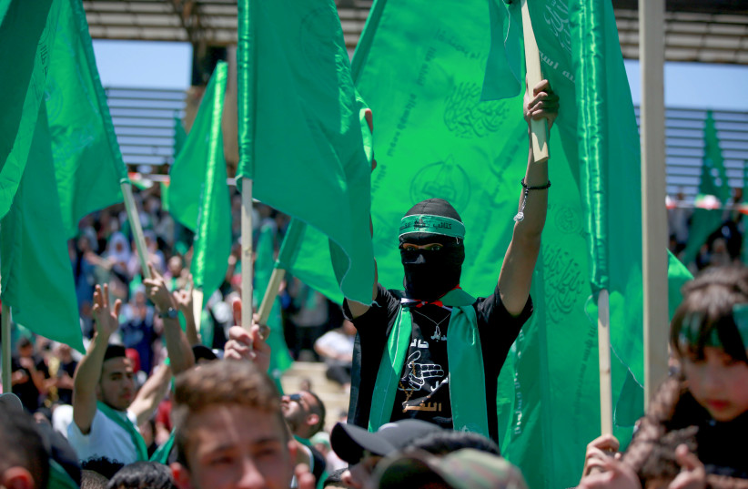 Palestinian students supporters of the Hamas movement wave the movement's flag during a rally at Birzeit University, near the West Bank city of Ramallah, May 19, 2022 (photo credit: FLASH90)