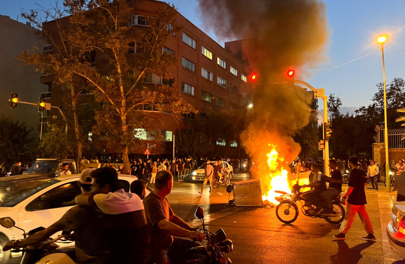  A police motorcycle burns during a protest over the death of Mahsa Amini, a woman who died after being arrested by the Islamic republic's ''morality police'', in Tehran, Iran September 19, 2022 (credit: WANA (WEST ASIA NEWS AGENCY) VIA REUTERS)