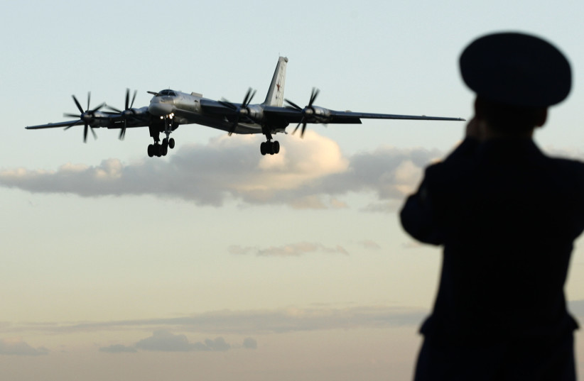 A Russian officer takes a picture of a TU-95 bomber, or Bear, at a military airbase in Engels some 900 km (559 miles) south of Moscow. (photo credit: REUTERS/SERGEI KARPUKHIN)