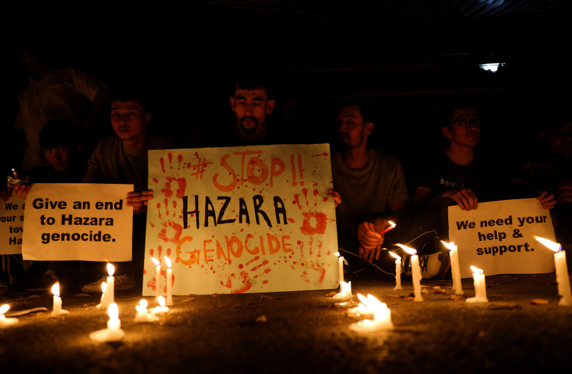 Afghan nationals, members of the Hazara minority hold placards and candles as they protest against the suicide attack at a tutoring center in west Kabul, outside the United Nations High Commissioner for Refugees (UNHCR) office, in New Delhi, India, September 30, 2022 (credit: REUTERS/ANUSHREE FADNAVIS)