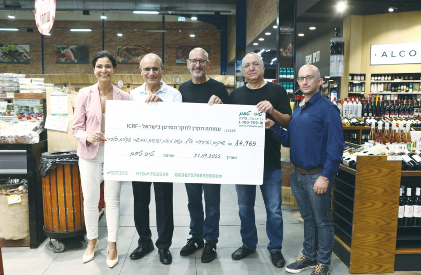  TIV TAAM check that will provide scholarships for Israelis engaged in cancer research is held up by (from left), Avivit Levi, Chagai Shalom, Tamir Gilat, Yosi Shalev and Lior Lapid.  (credit: ASAF LEV)