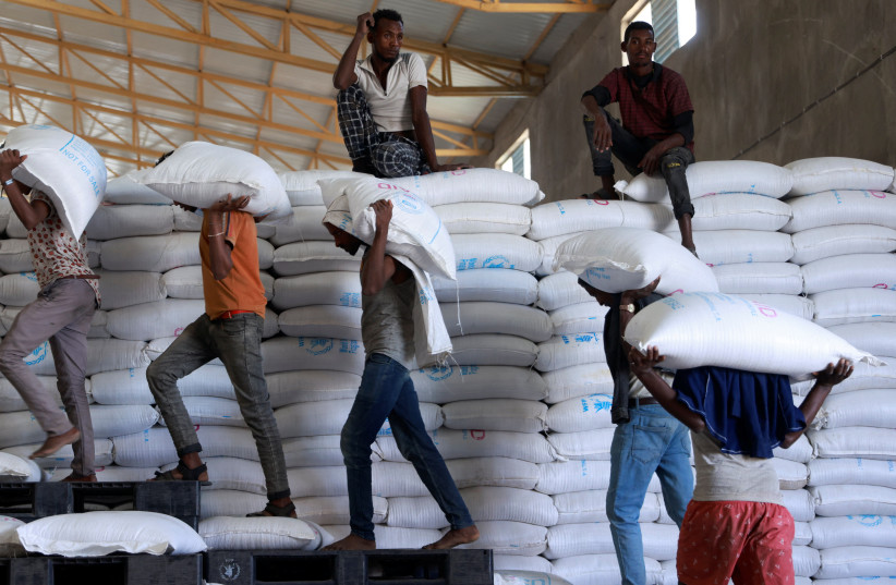  Labourers offload bags of grains as part of relief food that was sent from Ukraine at the World Food Program (WFP) warehouse in Adama town, Ethiopia, September 8, 2022.  (photo credit: REUTERS/TIKSA NEGERI)