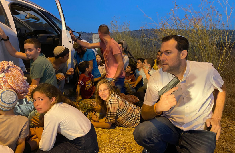 SAMARIA COUNCIL head Yossi Dagan and children shield behind a vehicle after Palestinians opened fire near Nablus.  (photo credit: Ido Ze'evi)
