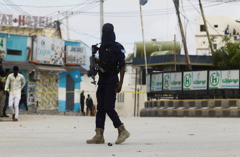 A Somali security officer walks at the entrance of Hotel Hayat, the scene of an al Qaeda-linked al Shabaab group militant attack in Mogadishu, Somalia August 20, 2022 (photo credit: REUTERS/FEISAL OMAR)