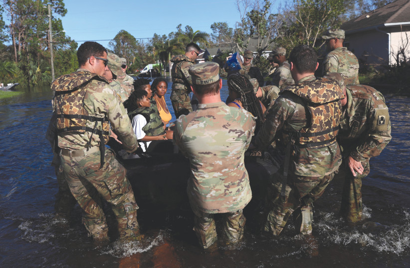  The US Army National Guard evacuates people from flooded areas in the aftermath of Hurricane Ian in North Port, Florida, last Friday. US politicians have proclaimed that if they were in charge, there would be no hurricanes as destructive as Ian. (photo credit: SHANNON STAPLETON/ REUTERS)