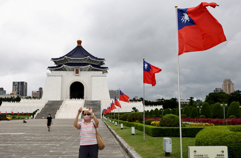 People take photos with Taiwan flags as part of the upcoming national day decoration in Taipei, Taiwan, October 6, 2022.  (photo credit: REUTERS/ANN WANG)