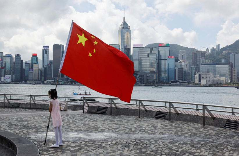  A child holds a Chinese national flag to celebrate Chinese National Day in Hong Kong, China October 1, 2022. (photo credit: REUTERS/TYRONE SIU)