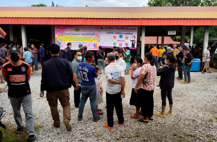  People gather outside of a daycare center's scene of a mass shooting in the town of Uthai Sawan, 500 km (310 miles) northeast of Bangkok in the province of Nong Bua Lamphu, Thailand October 6, 2022 (credit: SAKDIPAT BOONSOM/HANDOUT VIA REUTERS)