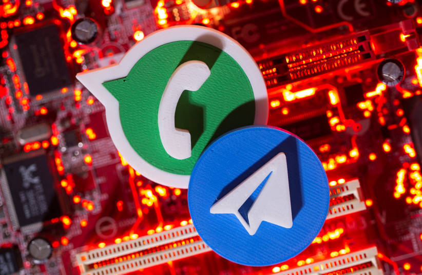  3D printed Telegram and WhatsApp logos are placed on a computer motherboard in this illustration taken January 21, 2021 (photo credit: DADO RUVIC/REUTERS ILLUSTRATION)