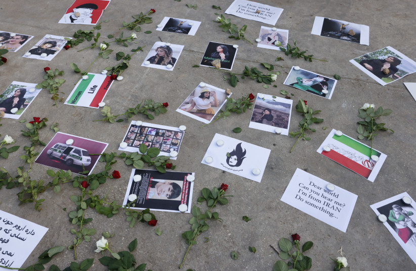 Pictures of Mahsa Amini and other Iranian women that were killed were displayed on the ground with flowers (photo credit: MARC ISRAEL SELLEM/THE JERUSALEM POST)