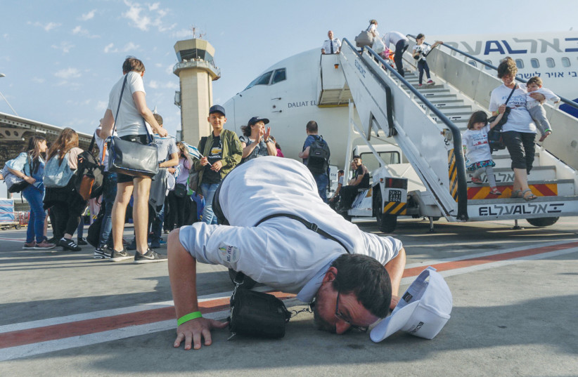  FRENCH JEWS arrive on aliyah at Ben-Gurion Airport, including a person who kisses the ground of Israel. Today, more than four out of every 10 Jews in the world live in Israel. (photo credit: NATI SHOHAT/FLASH90)