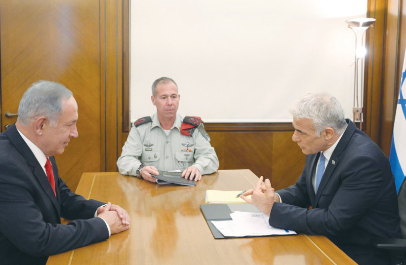  PRIME MINISTER Yair Lapid briefs opposition leader Benjamin Netanyahu on security and diplomatic matters, in the presence of the prime minister’s military secretary, Avi Gil, in August. Netanyahu called Lapid’s UN speech, ‘full of weakness, defeat and surrender.’ (photo credit: AMOS BEN GERSHOM/GPO)