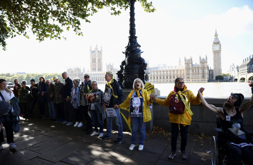 Supporters of WikiLeaks founder Julian Assange create a human chain outside Houses of Parliament during a protest, in London, Britain October 8, 2022 (photo credit: REUTERS/HENRY NICHOLLS)
