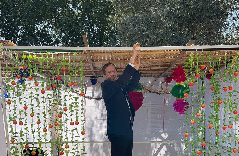  President Isaac Herzog sets up a sukkah at the President's Residence (credit: PRESIDENT'S RESIDENCE)