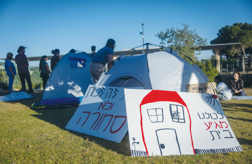  DEMONSTRATORS SET UP tents across from the Knesset, to protest soaring housing prices, earlier this year. One of the signs reads: ‘We all deserve a home.’ (credit: YONATAN SINDEL/FLASH90)
