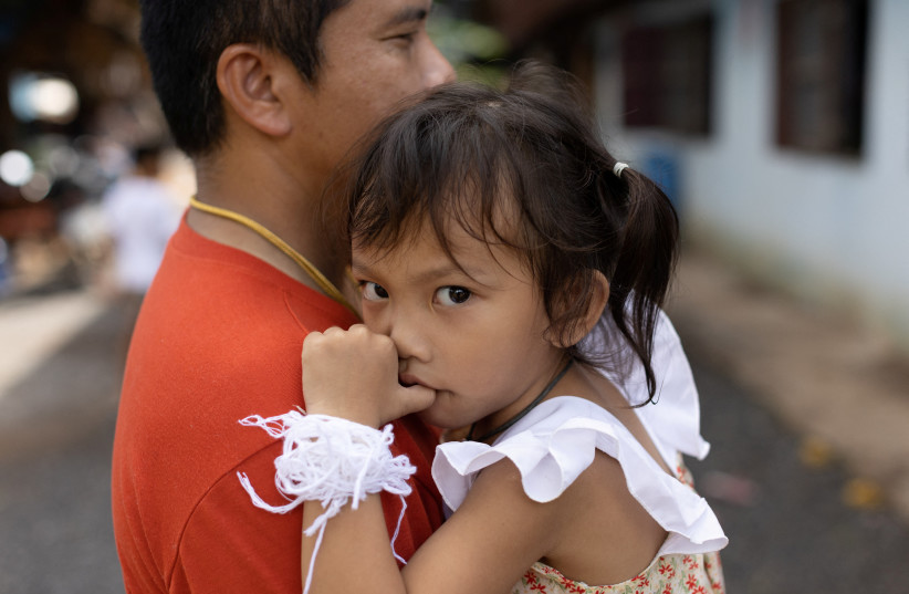  Tawatchai Supolwong holds his 3-year-old daugther Paveenut Supolwong, nicknamed Ammy, who is the only child survivor of the day care centre mass shooting, during a family meeting at their home in Uthai Sawan, Nong Bua Lam Phu province, Thailand, October 9, 2022. (photo credit: REUTERS/JORGE SILVA)