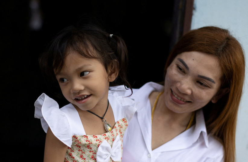  Panompai Sithong holds her daugther Paveenut Supolwong, the only child survivor of the mass shooting in Uthai Sawan. (credit: REUTERS/JORGE SILVA)
