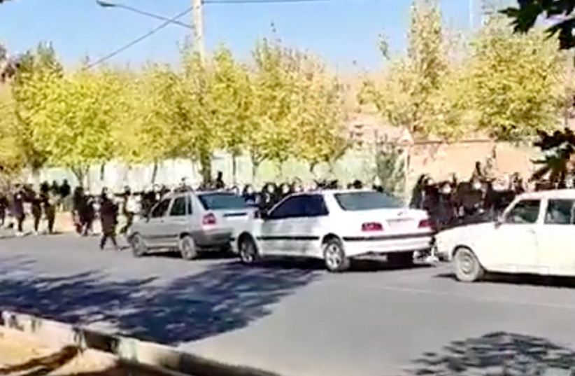 Protesters donning black march down the street following the death of Mahsa Amini in Saqez in Kurdistan Province, Iran October 4, 2022 in this screengrab obtained by Reuters from a social media video. (photo credit: TWITTER/VIA REUTERS)