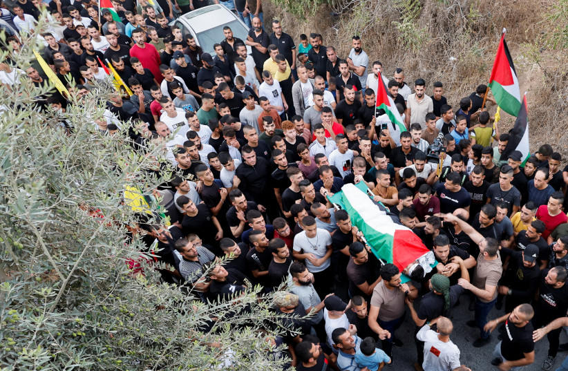 People carry the body of Mahmoud Samoudi, 12, who died of a wound he sustained during an Israeli raid in Jenin, during his funeral in the West Bank, October 10, 2022. (credit: REUTERS/RANEEN SAWAFTA)