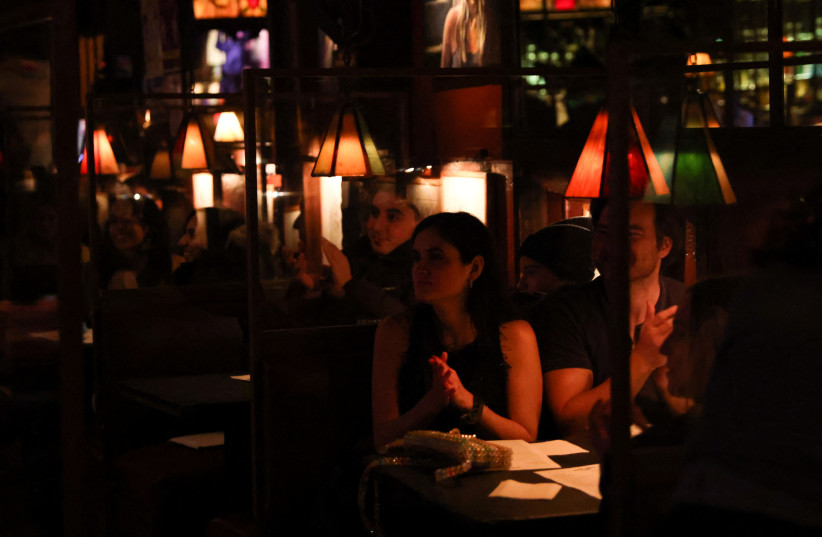  People watch a performance at Comedy Club on its first night back open after loosened restrictions during the continued outbreak of coronavirus disease (COVID-19) in Manhattan, New York, US, April 2, 2021. (photo credit: REUTERS/CAITLIN OCHS)